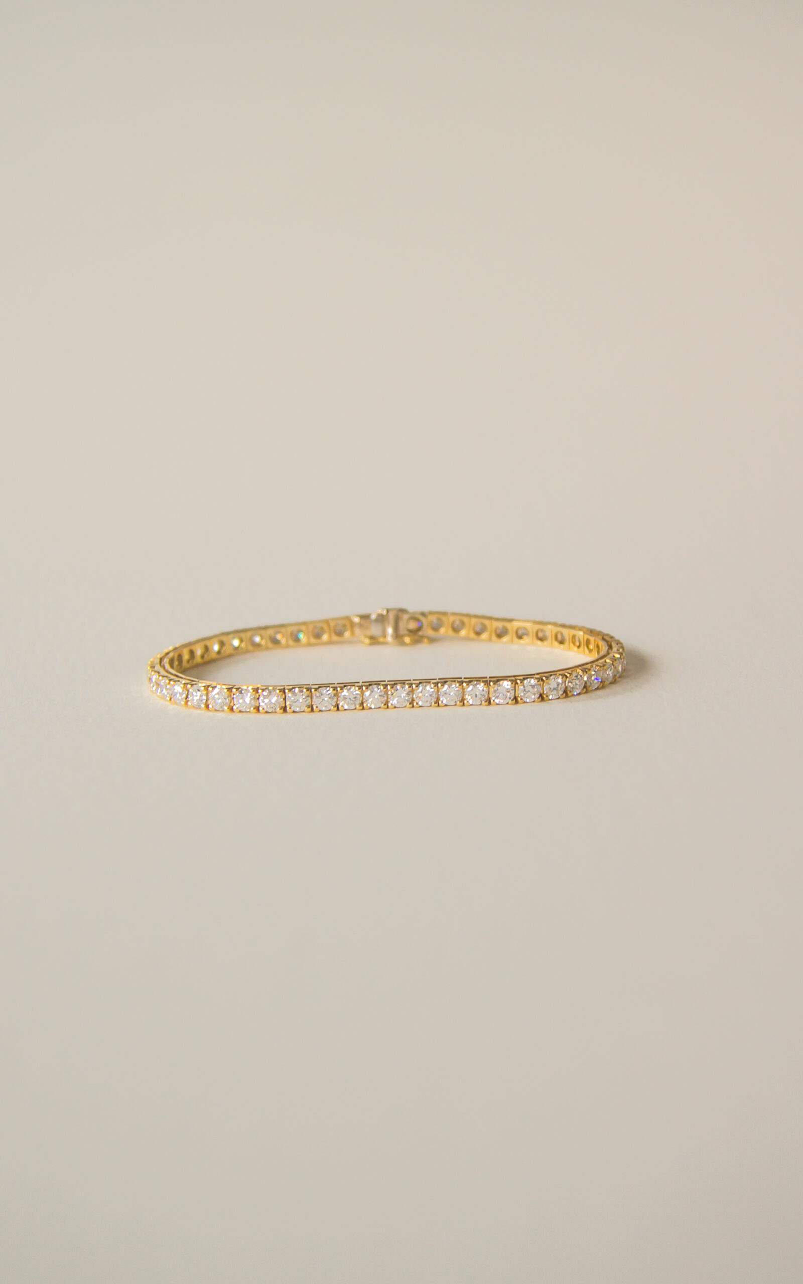 18K yellow gold classic tennis bracelet with round brilliant diamonds.